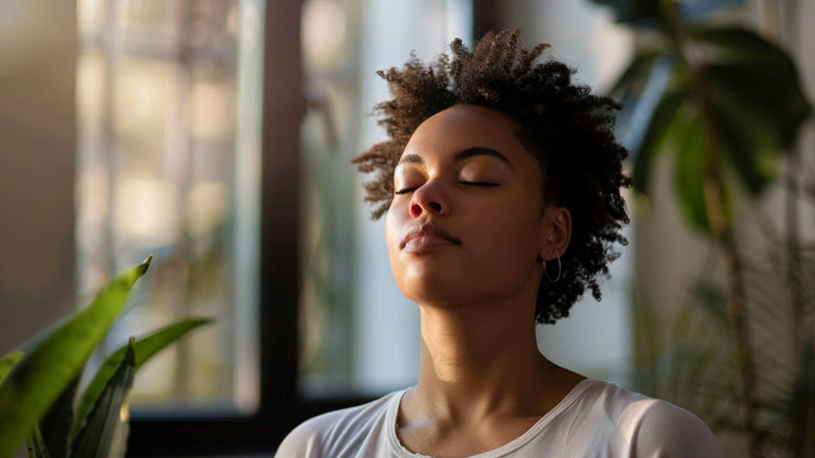 Calm woman enjoying clean air indoors, symbolising the benefits of air purifiers for a healthier home environment.