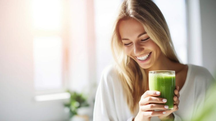 Smiling woman holding a green detox drink, featured in the blog 'Detox & Cleanse - The Good Stuff