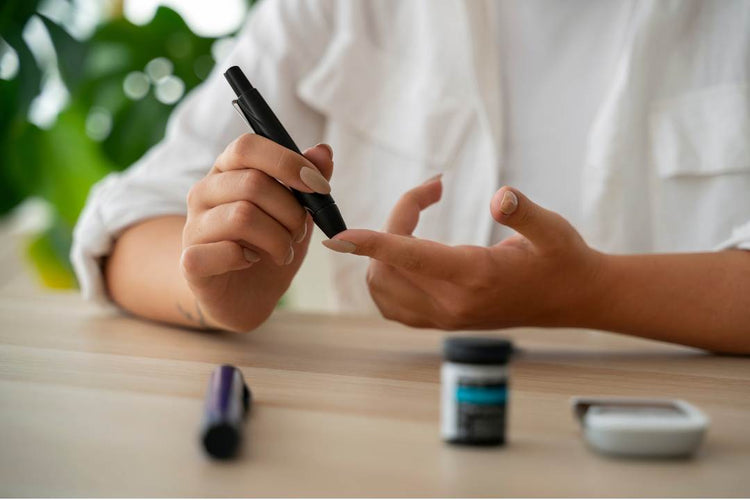 Close-up of a person checking blood sugar levels with a glucose monitor at a table, highlighting diabetes management and wellness support.