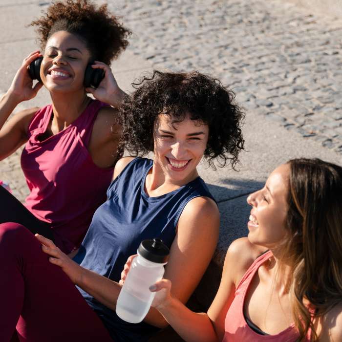 Insulin Resistance Supplements - Three women in athletic wear sitting outdoors, smiling and enjoying a post-workout break, representing a healthy and active lifestyle supported by supplements for managing insulin resistance.