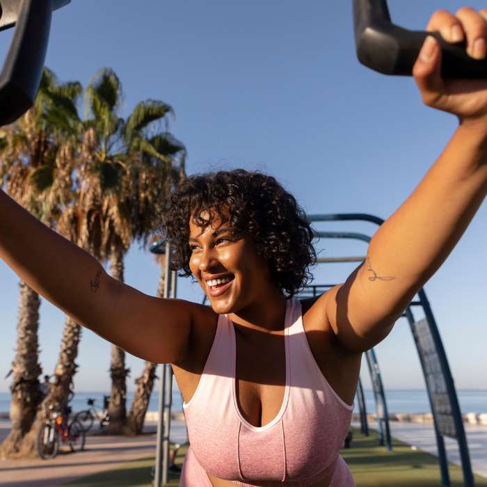 Smiling woman enjoying an outdoor workout, promoting a healthy lifestyle supported by liver detox supplements.