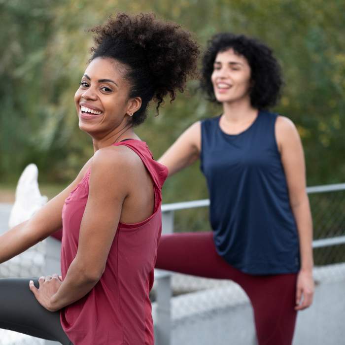 Two women stretching and smiling outdoors, representing the vitality and balance offered by natural estrogen supplements.