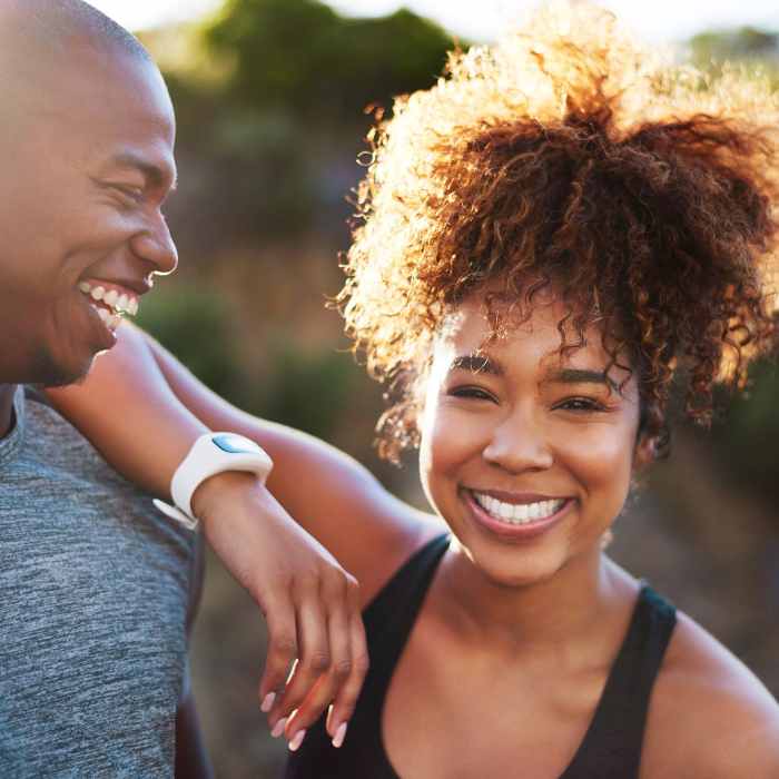 A smiling man and woman outdoors, showcasing the energy and vitality associated with vitamin B supplements.